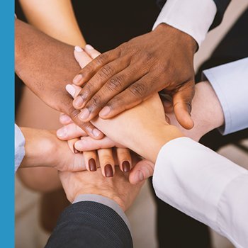 Hands of different ethnicities and genders huddled together