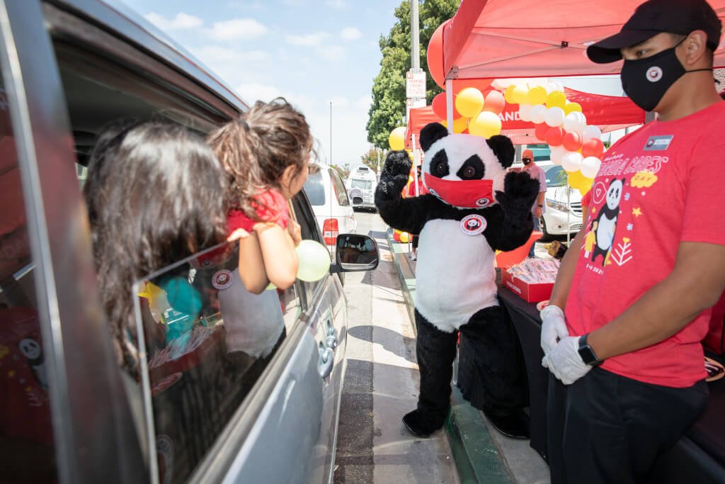 Car passengers watching Panda Cares mascot