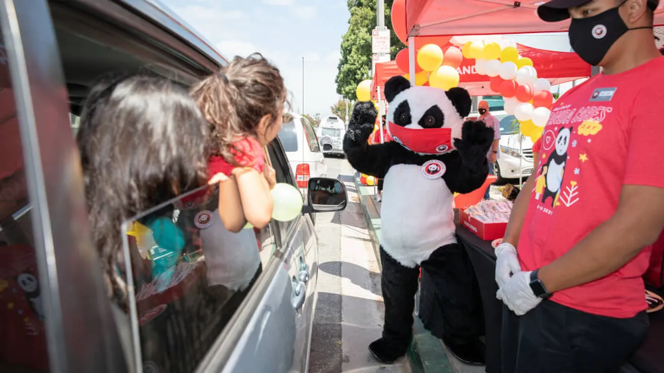 Car passengers watching Panda Cares mascot