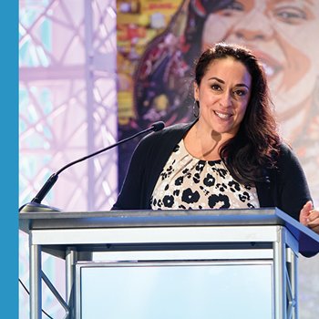 A woman speaking at a podium in a conference