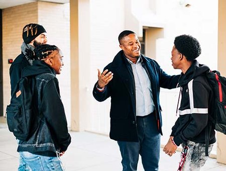 Cyril Jefferson speaking with 3 students